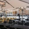 A large open air restaurant with tables and chairs.