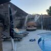 A pool with an outdoor fireplace and fire hydrant.